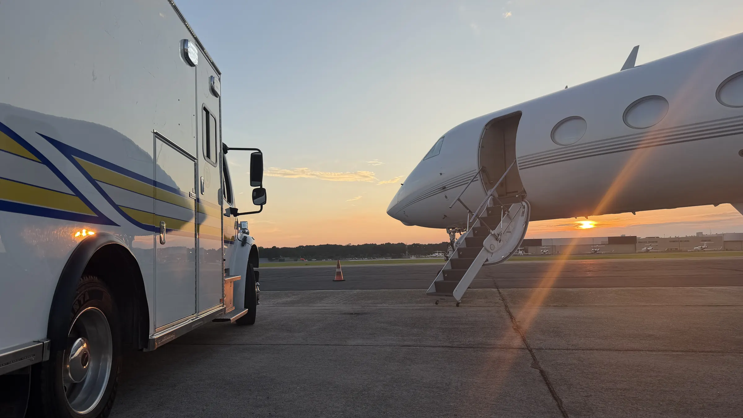 LCA's AOG truck parked beside a Gulfstream with its airstair down at sunset